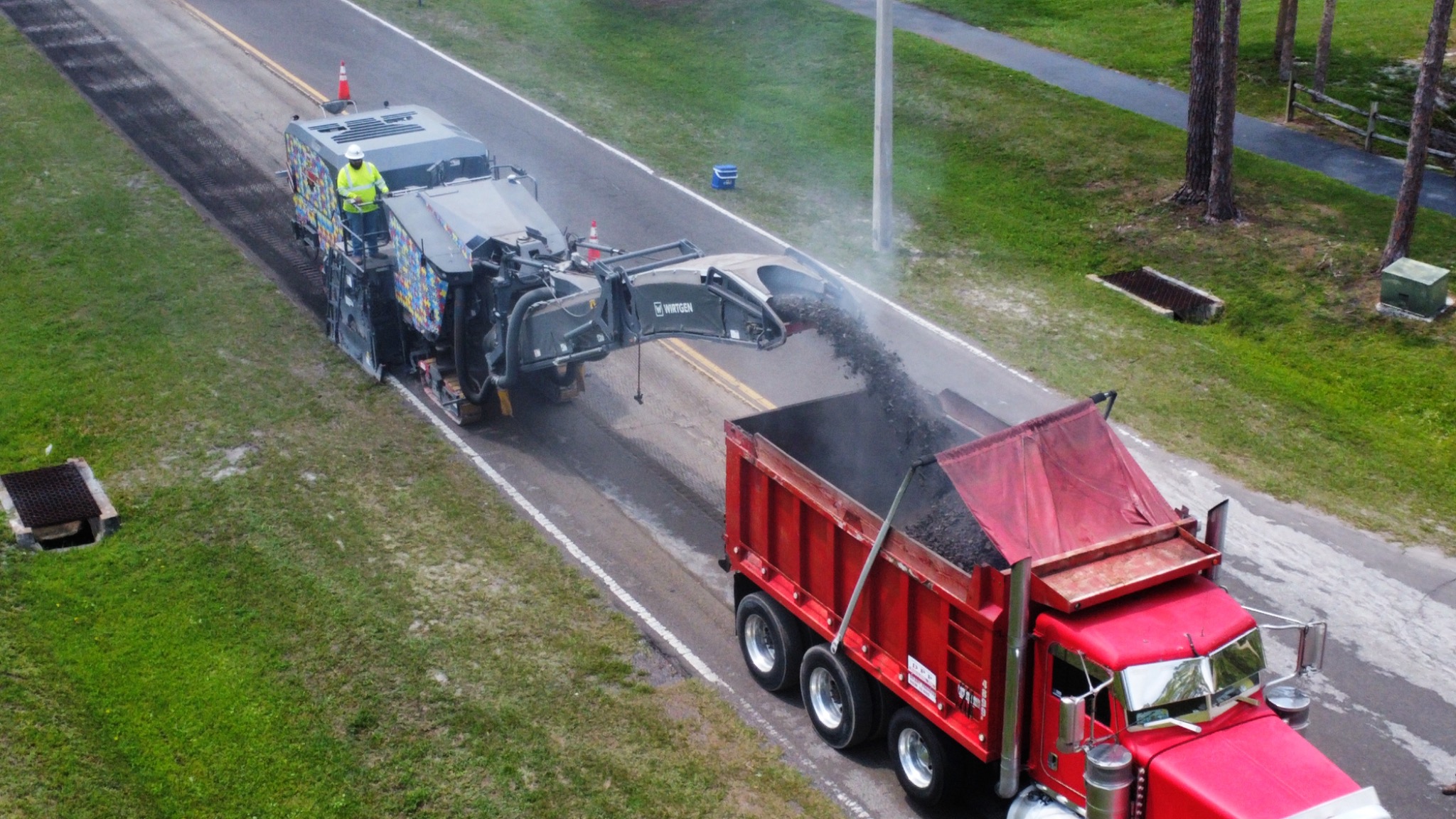 Asphalt miller and dump truck on road